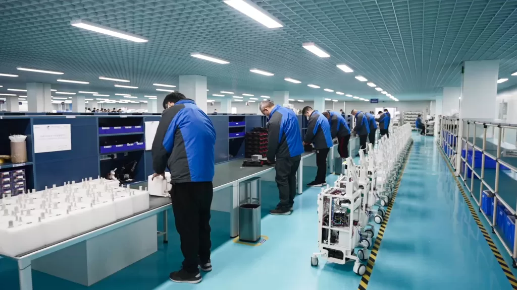 Workers assemble machines at PZLASER production workshop.