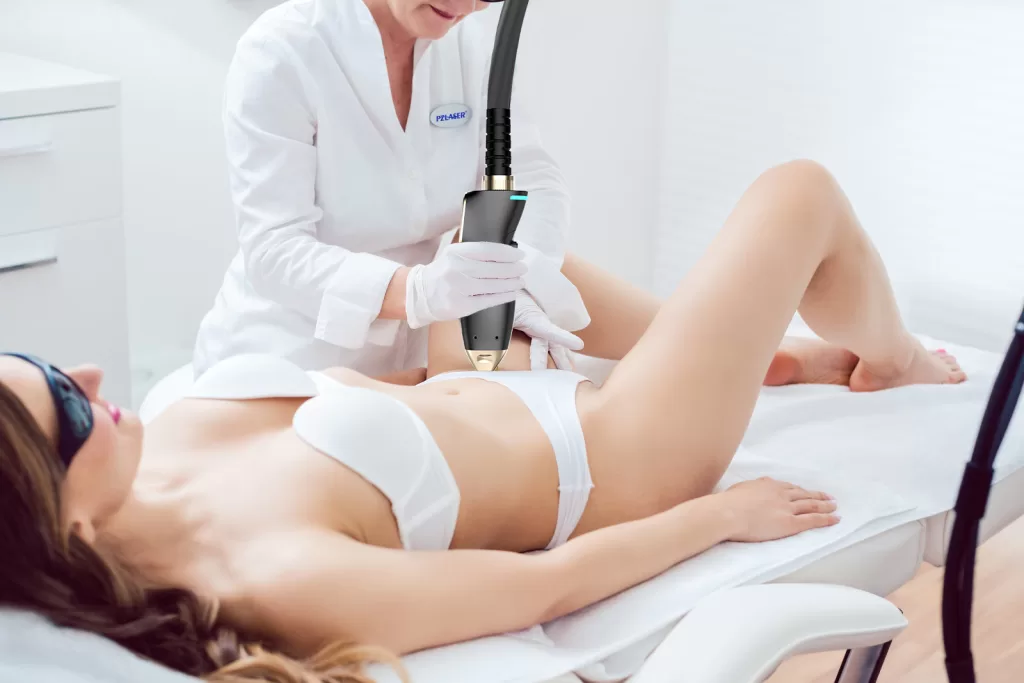 A therapist using painless laser technology for the hair removal in the bikini zone of a female client in a modern beauty salon